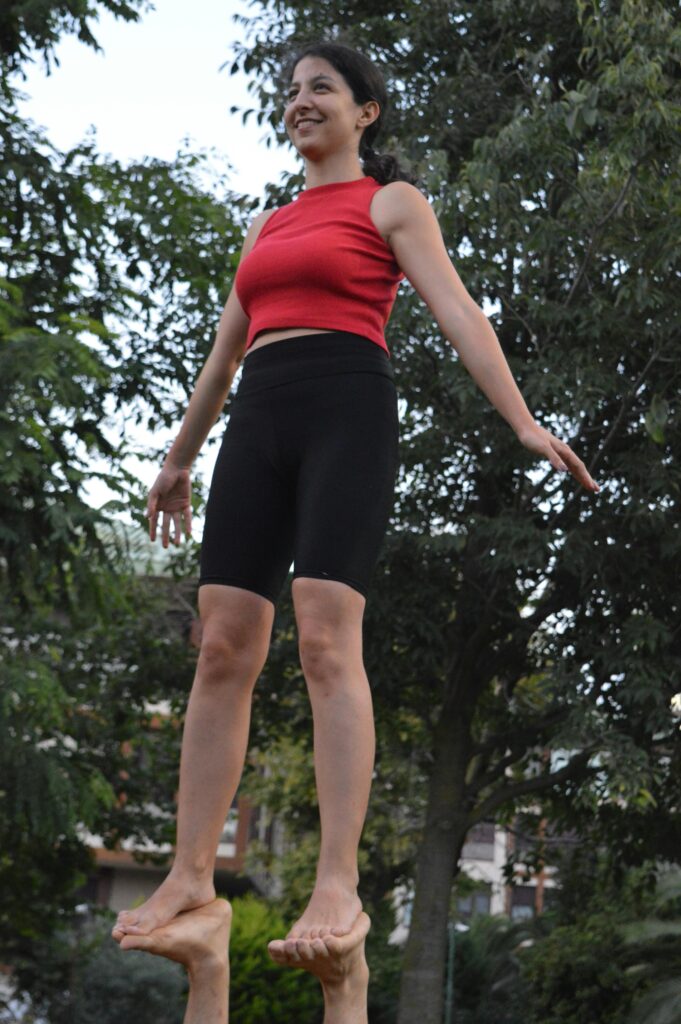 Outdoor acroyoga session with balancing pose showcasing focus and flexibility.